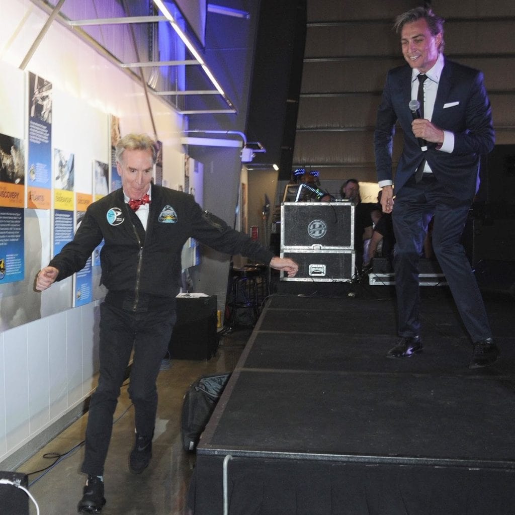 Gray Bright and Bill Nye running behind the stage at Yuri's Night